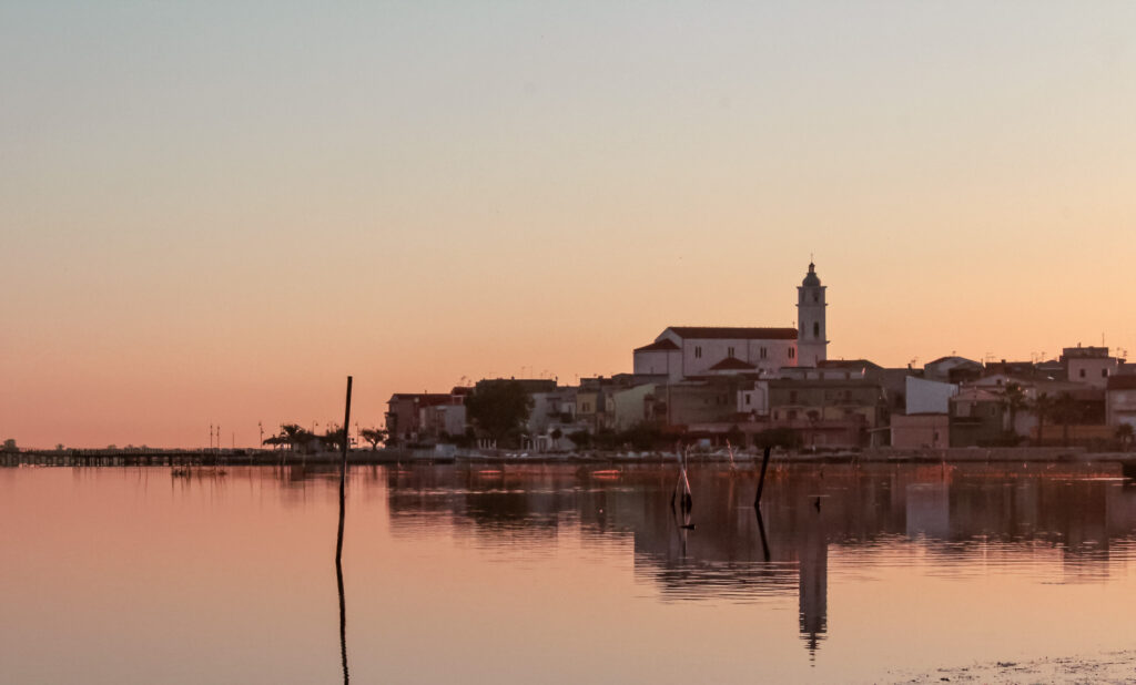 Il campanile della Cattedrale e le case del borgo di Lesina riflessi nel lago