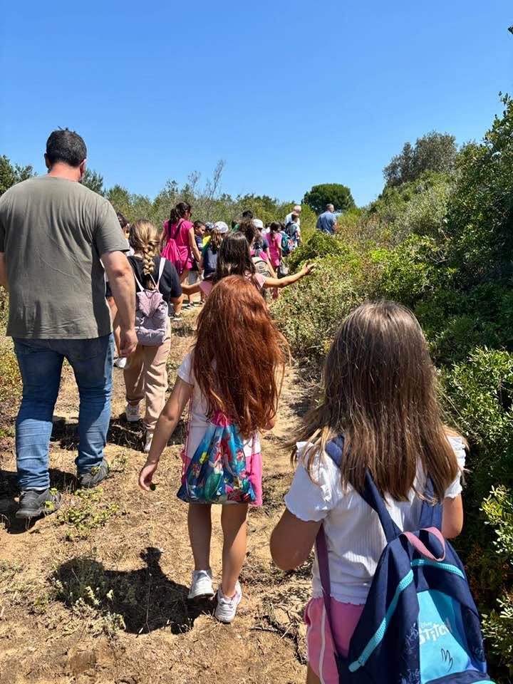 Bambini con lo zaino sul sentiero tra la macchia mediterranea del Bosco Isola